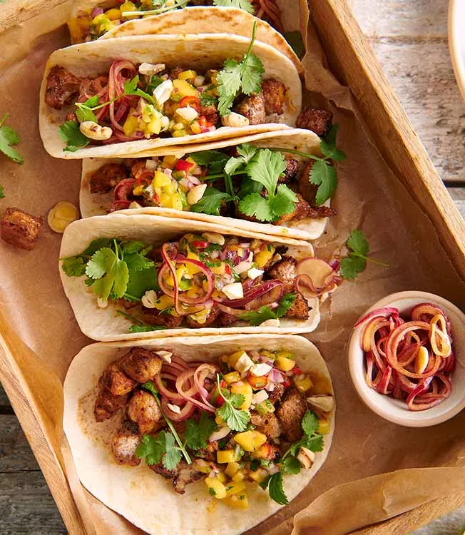 Tacos recheados com carne de porco e cebolas em pickle
