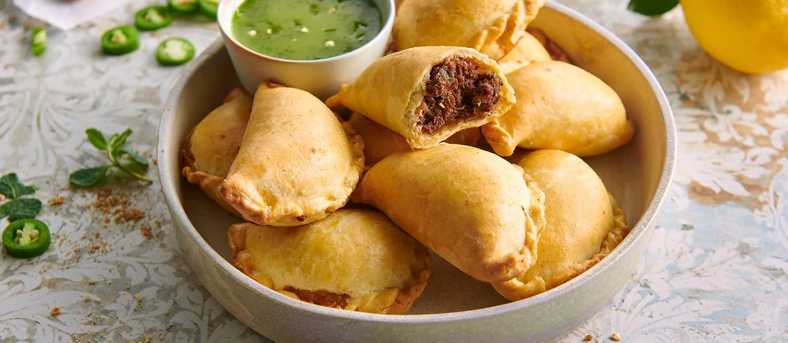 Empanadas de carne picante com molho de ervas verdes