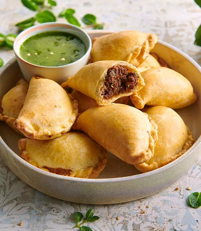 Empanadas de carne picante com molho de ervas verdes