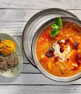 Estufado de lentilhas vermelhas com iogurte de especiarias e cubos de tâmaras
