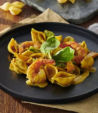 Conchiglie com camarões e legumes com molho de caril e natas